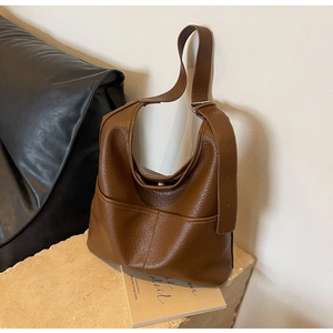 Détail du sac hobo marron montrant le cuir grainé litchi et la boucle réglable