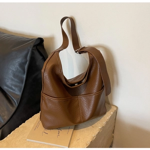 Détail d'un sac hobo marron avec large bandoulière réglable et boucle en métal argenté