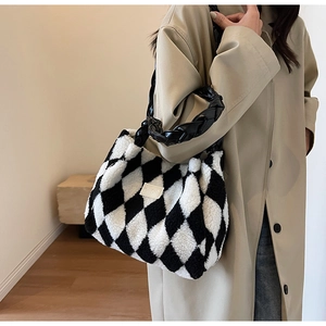 Detail of black and white checkered faux fur tote with woven handle on model