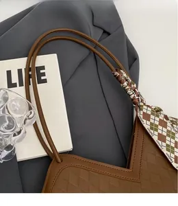 Detail of brown faux leather tote with diamond quilting and decorative silk scarf