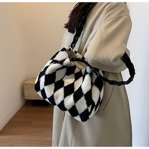 Close-up of black and white checkered faux fur tote with woven handle and metal tag