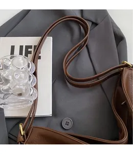 Detail of brown litchi pattern leather tote with long straps and internal zipper compartment
