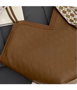 Close-up of brown quilted faux leather tote bag with stylish fashion silk scarf