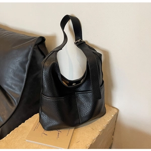 Détail du grand sac hobo noir avec texture grainée et boucle métallique réglable