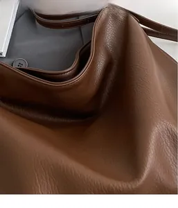 Detail shot of the soft dark brown lychee texture leather and durable shoulder strap