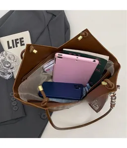 Top view of spacious interior storage in brown tote bag with tablet and books