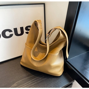 Gros plan détaillé du cuir grainé et de la poche latérale sur ce sac cabas kaki