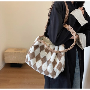 Detail of plush brown and white checkerboard tote with woven handles and leather logo