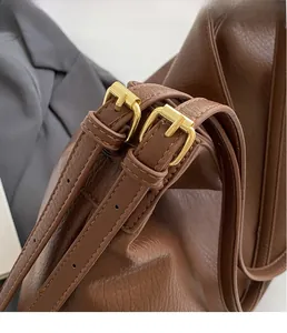 Detailed close-up of premium gold metal buckles and adjustable leather shoulder straps