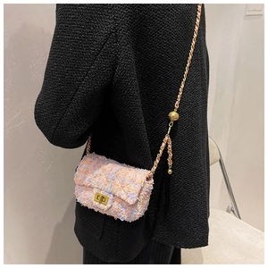 Detail of tweed crossbody bag featuring a golden ball adjustable chain and lock