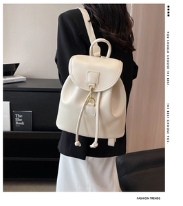 Détail d'un sac à dos en cuir crème avec fermeture à cordon porté par un mannequin