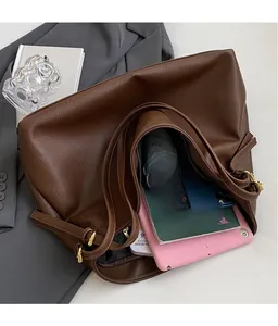 Detail of spacious dark brown tote bag showing capacity for tablet and umbrella