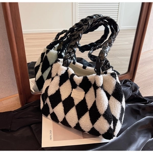 Detailed shot of black and white checkerboard plush tote bag with woven leather handles