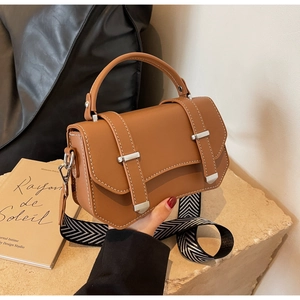 Detail of caramel leather bag with white contrast stitching and geometric wide strap
