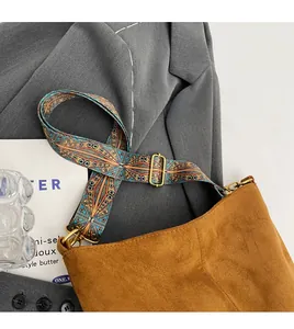 Close-up of adjustable jacquard wide shoulder strap on brown suede tote bag
