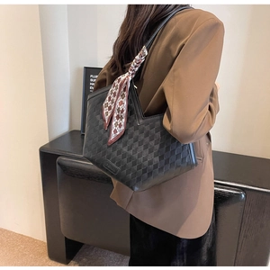 Detail of black tote bag with checkered texture and decorative silk scarf accessory