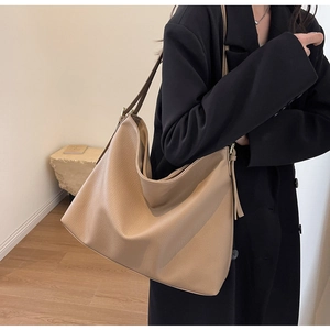 Detailed macro view of high-quality lychee textured leather on large khaki tote bag