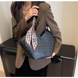 Close-up of black quilted tote bag featuring a V-shaped cut and silk scarf detail