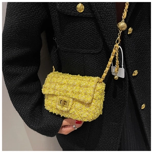 Close-up of yellow tweed crossbody bag with gold chain strap and metal turn-lock closure