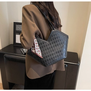 Detail of black woven quilted tote bag with silk scarf on brown blazer model
