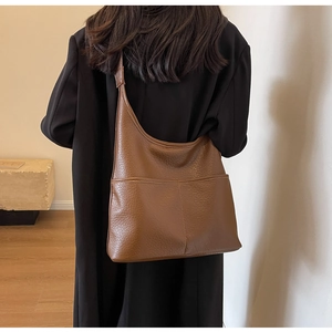 Détail du sac hobo marron montrant la grande capacité et la texture du cuir grainé
