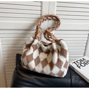 Close-up of fluffy checkerboard tote bag with sheepskin texture and leather handle