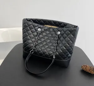 Dettaglio del motivo a rombi trapuntati e della tracolla a catena della borsa nera