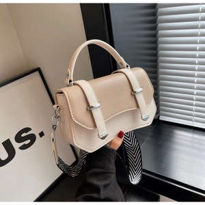 Close-up of contrast leather texture and silver buckles on the small square bag