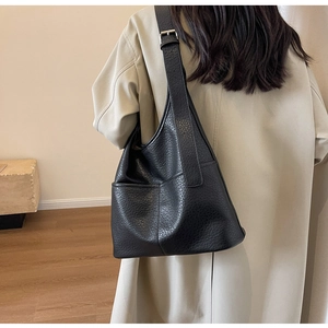 Détail du sac à bandoulière noir grainé avec large sangle et boucle métallique ajustable