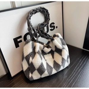 Close-up of plush tote bag featuring grey and white rhombus pattern and braided handle