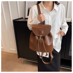 Détail d'un sac à dos en similicuir marron avec cordon de serrage et crochet doré