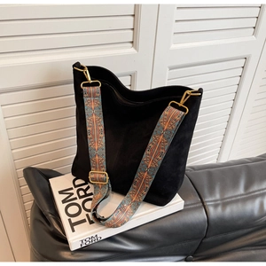 Detail of black matte tote bag featuring colorful bohemian wide woven shoulder strap