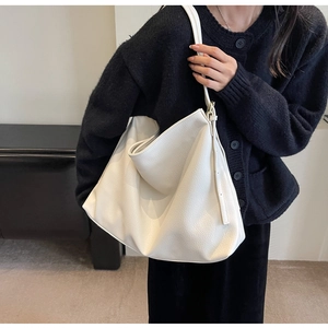Close-up of white pebble-textured large capacity tote bag with adjustable shoulder strap