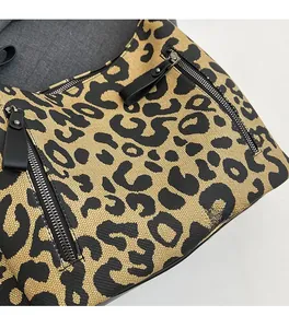 Detailed macro view of leopard print woven canvas texture and matte black metal zipper