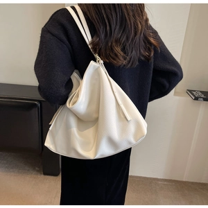 Detailed shot of white lychee texture shoulder bag showing soft silhouette and strap