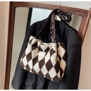 Detail of checkered plush tote bag with braided brown handle and soft fleece texture