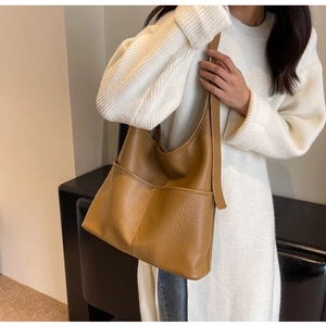 Détail du sac cabas en cuir grainé caramel montrant la texture douce et les poches larges