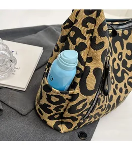 Detail of leopard print canvas tote bag featuring a functional side pocket for water bottles