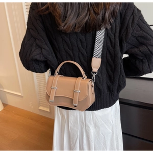 Detail of camel crossbody bag with textured faux leather and striped wide shoulder strap