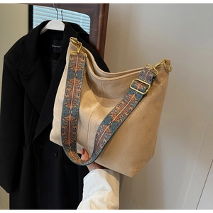 Detail of bohemian woven wide shoulder strap on a matte vintage tote bag