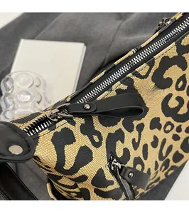 Detail of leopard print tote featuring metal zipper and black leather puller