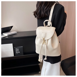 Détail d'un sac à dos en cuir blanc crème avec cordon de serrage et boucle dorée élégante