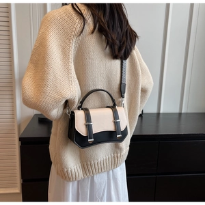 Detail of crossbody bag featuring a wavy base design and geometric woven wide strap