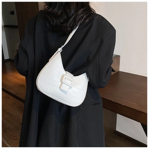 Detail of white crocodile pattern hobo bag with stylish square buckle on a black suit
