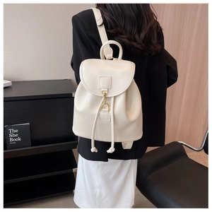 Vue arrière du modèle portant un sac à dos en cuir blanc avec détails en métal doré