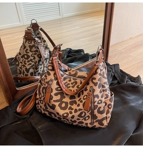 Détail du sac cabas en toile léopard avec poignées en cuir et poches zippées
