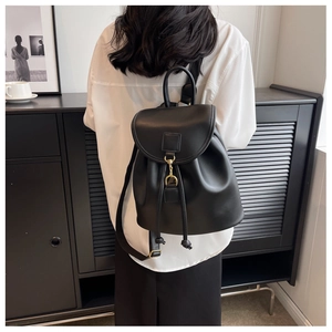 Détail du sac à dos en cuir noir avec fermeture à cordon et boucle métallique de fixation