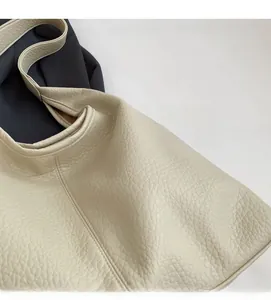 Detailed macro view showing the soft lychee texture leather of this large tote bag