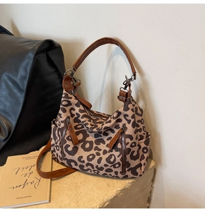 Détail du sac cabas en toile à motif léopard avec bandoulières en cuir marron et zips