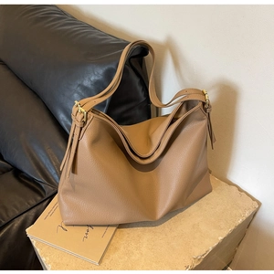 Detail view of khaki brown large capacity tote bag with lychee grain texture and tassels